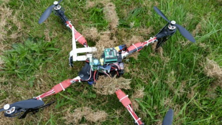 A quadcopter fitted with a Raspberry Pi, sat on grass