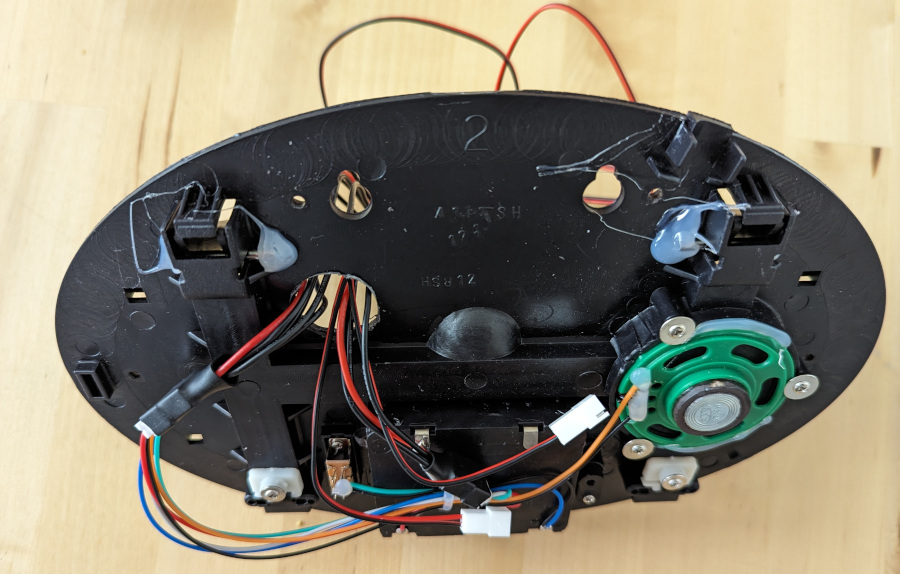 Inside rear of Billy Bass with four short cable extenders passing through a hole