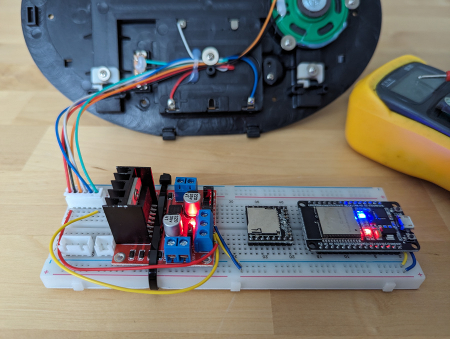 Rear shell of Billy Bass with breadboard in front. The breadboard has a motor driver and microprocessor board, both powered.